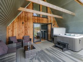An outdoor seating area with a hot tub at Valley View Hideaway in Ffostrasol