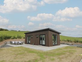 A house with patio furniture and grass at Rydlan in Aberystwyth