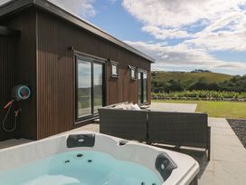 An outdoor area with a hot tub and seating at Rydlan in Aberystwyth