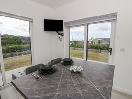 A dining room with a table and tv at Rydlan in Aberystwyth