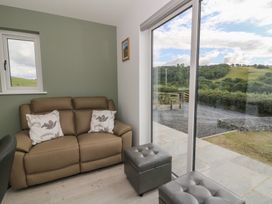 A snug with a sofa and footstools at Rydlan in Aberystwyth