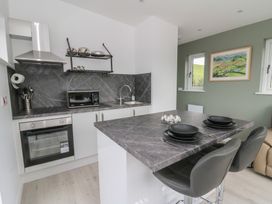 A kitchen with counter and stools at Rydlan in Aberystwyth