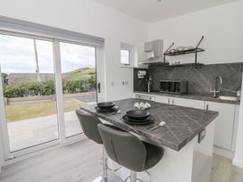 A kitchen with a dining area and appliances at Rydlan in Aberystwyth