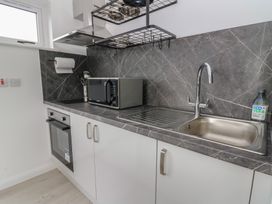 A kitchen with a microwave, oven, and sink at Rydlan in Aberystwyth