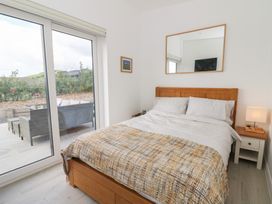 A bedroom with a bed and sliding doors at Rydlan in Aberystwyth