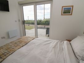 A bedroom with a bed and a view outside at Rydlan in Aberystwyth