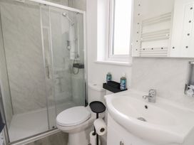 A bathroom with a shower, toilet, and sink at Rydlan in Aberystwyth