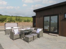 An outdoor seating area with a hot tub and table at Rydlan in Aberystwyth