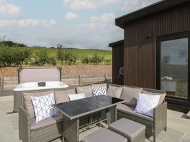 An outdoor seating area with a hot tub and table at Rydlan in Aberystwyth