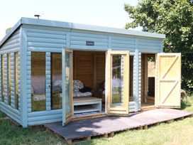 An outdoor structure with open doors and furniture at Holmside Audley Brow near Market Drayton