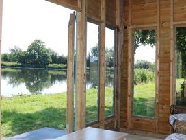 A room with large windows overlooking a lake at Holmside Audley Brow near Market Drayton