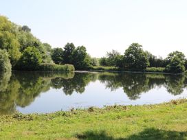 A lake surrounded by trees and grass at Holmside Audley Brow near Market Drayton