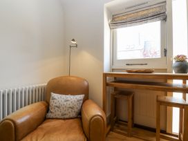 A snug with an armchair and a window at The Little Loft in Burford