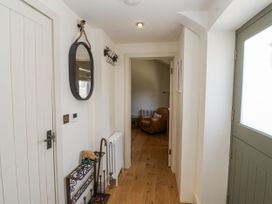 A hallway with a mirror and a coat rack at The Little Loft in Burford
