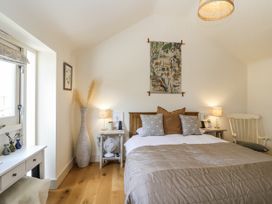 A bedroom with a bed and a lamp at The Little Loft in Burford