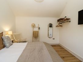 A bedroom with a bed and chair at The Little Loft in Burford