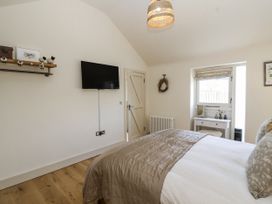 A bedroom with a bed and television at The Little Loft in Burford