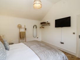 A bedroom with a bed and TV at The Little Loft in Burford