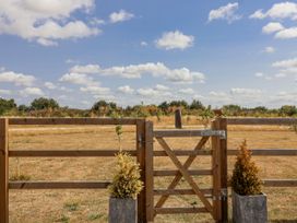 A wooden gate with planters and a grassy area at The Little Loft in Burford