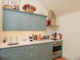 A kitchen with cabinets and appliances at The Little Loft in Burford