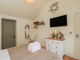 A bedroom with a bed and a television at The Little Loft in Burford