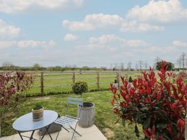 A garden with a table and chair at The Little Loft in Burford