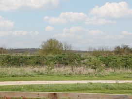 A view of trees and bushes with a pathway at The Little Loft in Burford