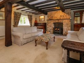 A living room with two sofas a stone fireplace and a piano at New Hall in Chirk