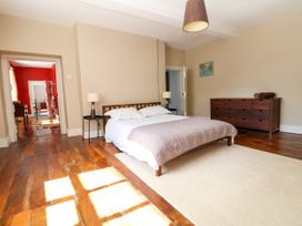 A bedroom with a double bed with lamps on both sides and a wooden dresser at New Hall in Chirk