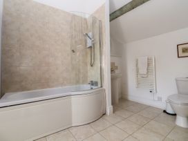 A bathroom with a bathtub shower combination sink toilet and towel rack at New Hall in Chirk