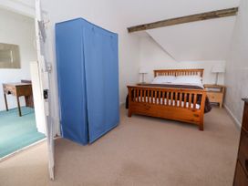 A bedroom with a wooden bed and two lamps on bedside tables and a blue wardrobe at New Hall in Chirk