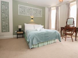 A bedroom with a bed and a dressing table at Watermouth Castle, Penn-Curzon Apartment, Berrynarbor near Ilfracombe