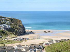 A view of a beach and ocean with houses at Watermouth Castle, Rhododendron Apartment Berrynarbor near Ilfracombe