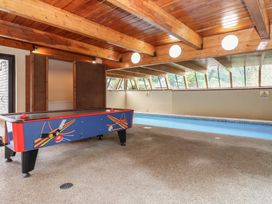 An indoor pool area with an air hockey table and a swimming pool at Watermouth Castle, Clock Tower Apartment, Berrynarbor near Ilfracombe