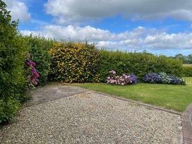 A garden with flowers and gravel at Bryn Tawel in Eglwyswrw