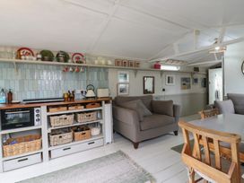 A kitchen area with a sofa and dining table at The Artist's Cabin By The Sea in Herne Bay