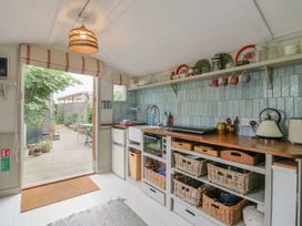 A kitchen with a sink and shelves at The Artist's Cabin By The Sea in Herne Bay