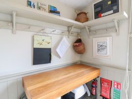A utility room with a table and storage shelves at The Artist's Cabin By The Sea in Herne Bay
