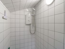 A shower with tiles and water control unit at The Artist's Cabin By The Sea Herne Bay