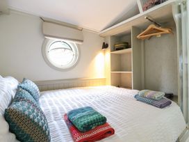A bedroom with a bed and shelves at The Artist's Cabin By The Sea, Herne Bay