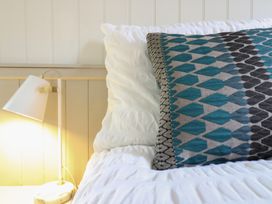 A bed with a patterned pillow and lamp at The Artist's Cabin By The Sea Herne Bay