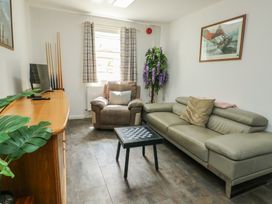 A living room with a sofa, armchair, and coffee table at The Bevan in Bontnewydd, Gwynedd