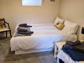 A bedroom with a bed and a chair at The Old Nant-y-Fflint Chapel in Pentre Halkyn near Holywell