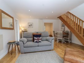 A living room with a sofa and dining area at Mariners Rest in Gorran Haven
