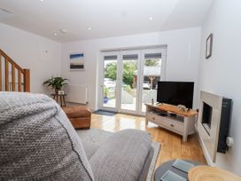 A living room with sliding doors and a television at Mariners Rest in Gorran Haven