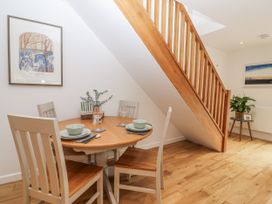 A dining area with a round table and chairs at Mariners Rest in Gorran Haven