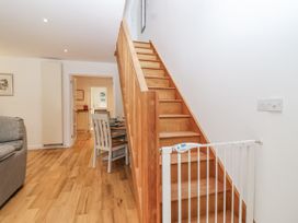 A living room with a staircase and dining area at Mariners Rest in Gorran Haven