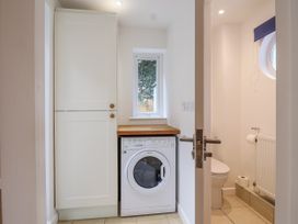 A laundry room with a washing machine and a toilet at Mariners Rest in Gorran Haven
