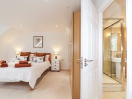 A bedroom with a bed and attached shower at Mariners Rest in Gorran Haven