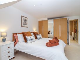 A bedroom with a bed and wardrobe at Mariners Rest in Gorran Haven
